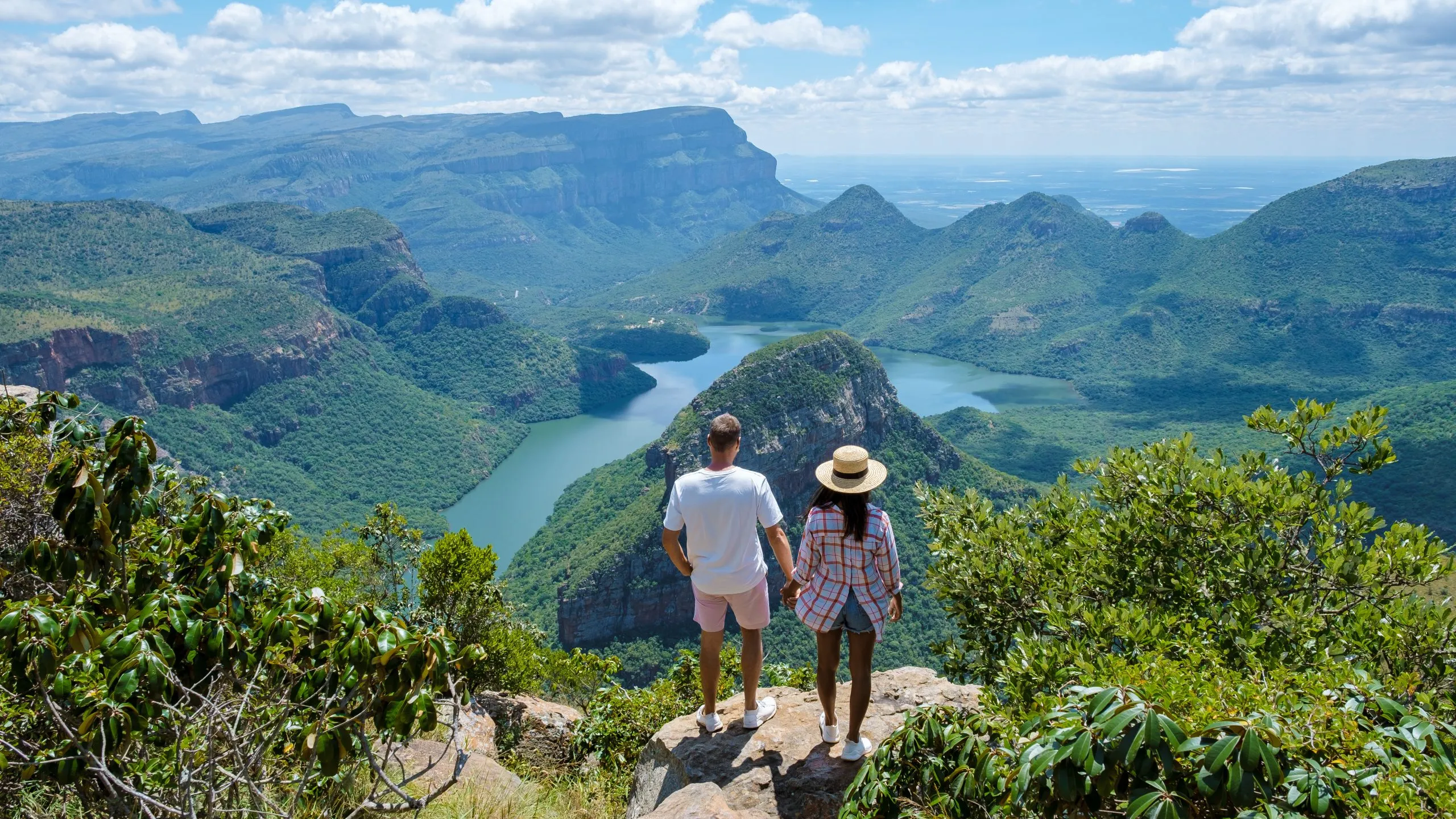 Panorama Route Sydafrika, Blyde River Canyon med de tre rondellerna, utsikt över tre rondeller och Blyde River Canyon i Sydafrika. Asiatiska kvinnor och kaukasiska män på semester i Sydafrika