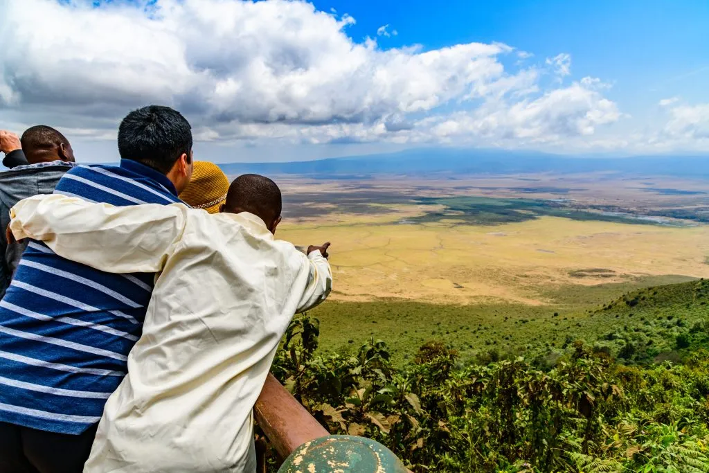 Uitzicht op de Ngorongoro krater in Tanzania. Beschermd gebied Ngorongoro. Afrikaans landschap. Gids toont iets aan toeristen